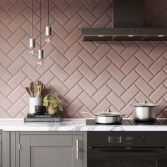 a stove top oven sitting inside of a kitchen next to a wall covered in tiles