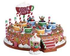 an assortment of candy and candies on display in a christmas themed centerpiece with the word cocoa cups above it