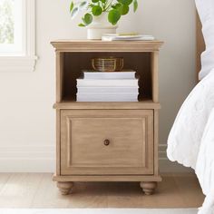 a nightstand with books and a potted plant on top