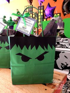 green paper bags with black and white designs on them are sitting on a wooden table