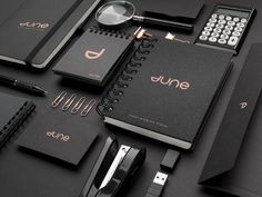 a black table topped with notebooks, pens and calculator next to each other