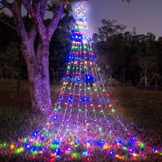 a lighted christmas tree in the middle of a field