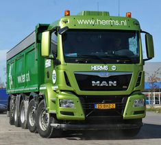 a green truck is parked on the street