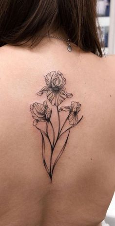 the back of a woman's shoulder with flowers tattoo on her left arm and chest