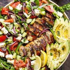 a salad with chicken, cucumber, tomatoes and onions in it on a plate