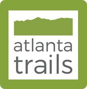 the atlanta trails logo on a green square with mountains in the background and white lettering