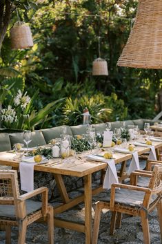 an outdoor dining area with wicker chairs and tables set up for a formal meal