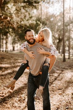 a man carrying a woman on his back in the woods