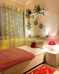 a bed room with a neatly made bed next to a window and a red rug