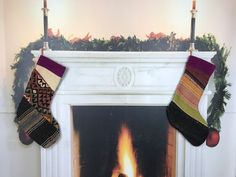 two stockings hanging over a fireplace with a fire