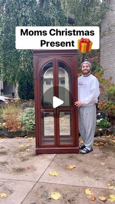 a man standing in front of a display case with the words moms christmas present on it