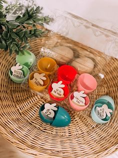 several different colored cups sitting on top of a wicker basket