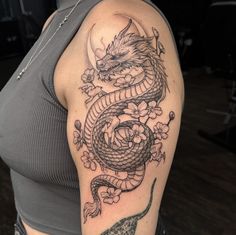 a woman's arm with a dragon tattoo on the left side of her body