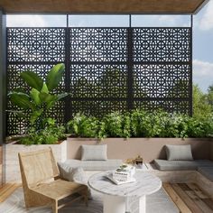 an outdoor living area with couches, tables and potted plants