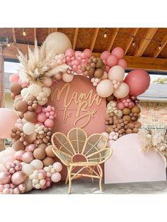 a pink and gold balloon arch with the word happy on it, surrounded by balloons