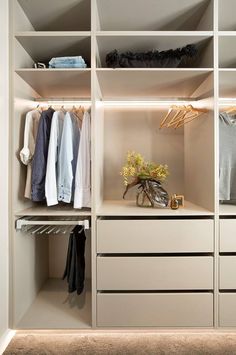 an organized closet with white shelves and drawers