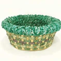 a green and yellow basket sitting on top of a white table