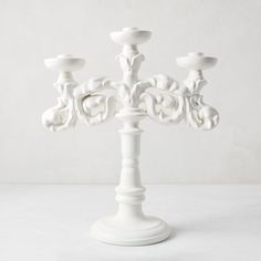 a white candelabra with four candles on it