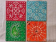 four different colored tile designs on a white surface with one green, one red and one blue