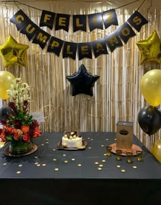 a black table topped with cake and balloons