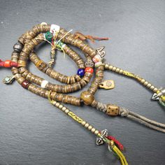 an assortment of beaded necklaces and bracelets on top of a black surface