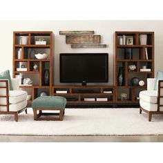 a living room filled with furniture and a flat screen tv on top of a wooden entertainment center