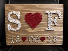 a wooden sign with the word love spelled in white and red