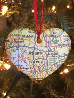 a heart shaped ornament hanging from a christmas tree with the map of atlanta on it