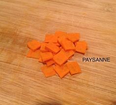 chopped up carrots sitting on top of a wooden cutting board with the word paysanne written across it