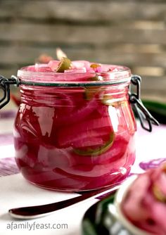 a jar filled with pickles sitting on top of a table