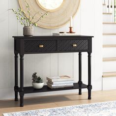 a black console table with two drawers and a mirror on the wall next to it