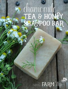 a bar of soap sitting on top of a wooden table next to some wildflowers