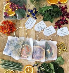 herbs and orange slices on a wooden table with tags attached to them that say good luck