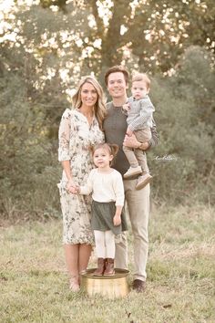 a family posing for a photo in the woods with their toddler son and mom