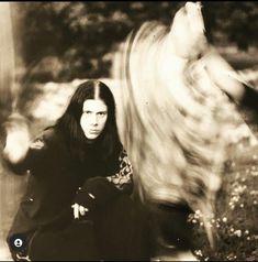 an old photo of a woman sitting on the ground