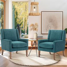 two blue chairs sitting in front of a window next to a table with a vase on it