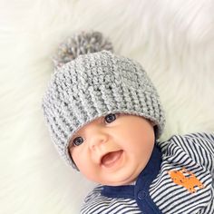 a smiling baby wearing a knitted hat