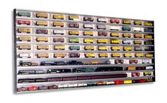 there is a large display of train cars on the side of this wall that has multiple rows of different colors and sizes