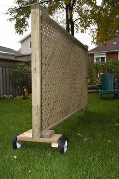 a wooden structure sitting on top of a lush green field next to a blue lawn chair