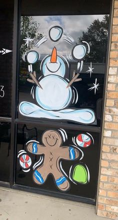 a frosty snowman sitting in front of a window