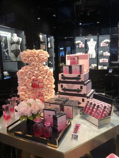 a table topped with lots of boxes and vases filled with flowers on top of it