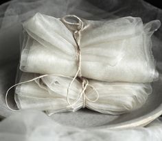 three pieces of white cloth wrapped in twine on top of a plate with string