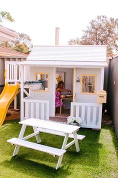 a child's play house with a slide and picnic table