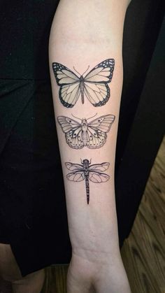 a woman's arm with three different butterflies on the left side of her arm