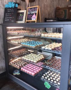 a display case filled with lots of different types of cupcakes and pastries