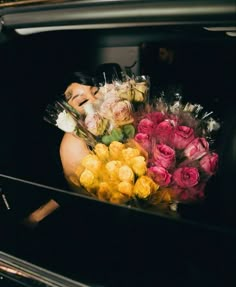 a bunch of flowers that are sitting in the back of a car with a woman's face on it