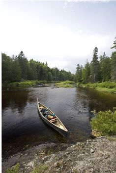 a canoe is sitting on the edge of a river