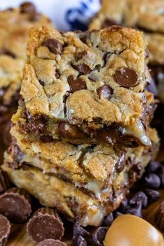 chocolate chip cookie bars stacked on top of each other with an egg in the background