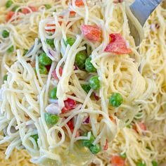 a close up of a pasta salad with peas and carrots