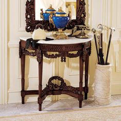 a table with a mirror, vase and other items sitting on it in front of a doorway